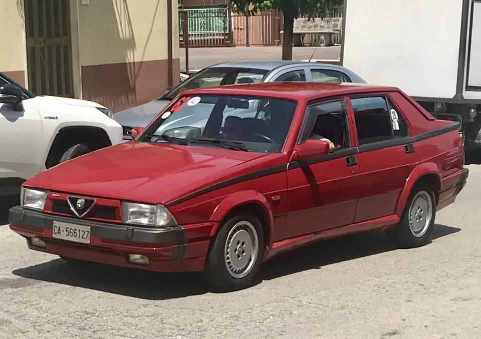 Red Alfa Romeo 75 Turbo saloon, front three-quarter view