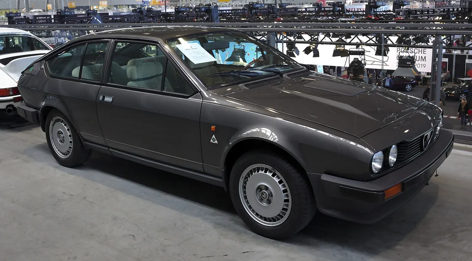 Grey Alfa Romeo GTV6, front three-quarter view at an indoor classic show