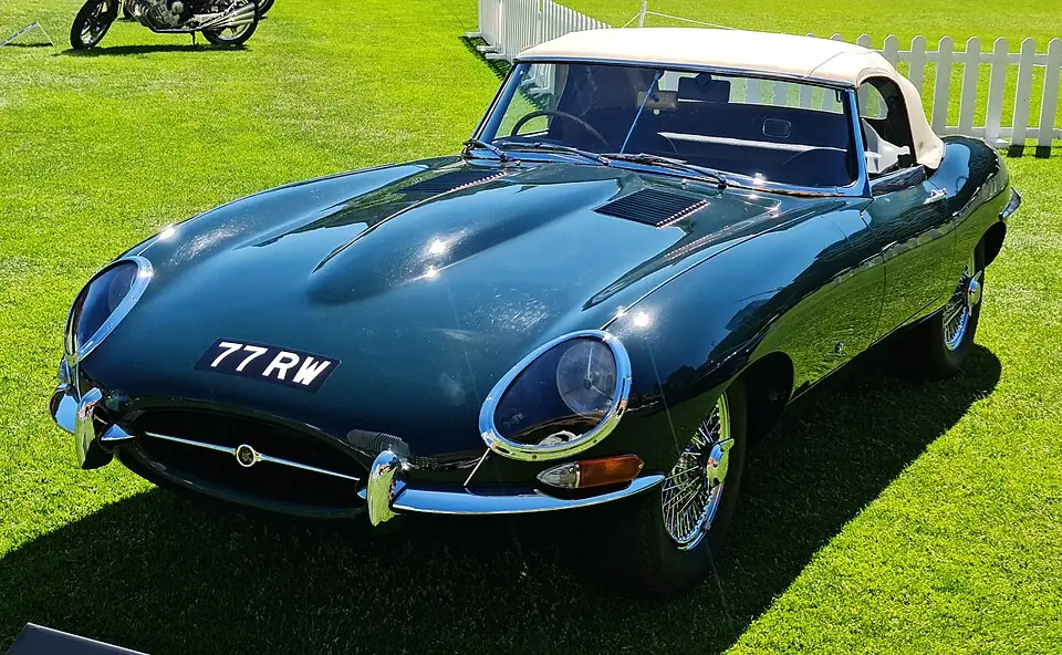 British Racing Green Jaguar E-Type Series 1 roadster, front three-quarter view, soft top up