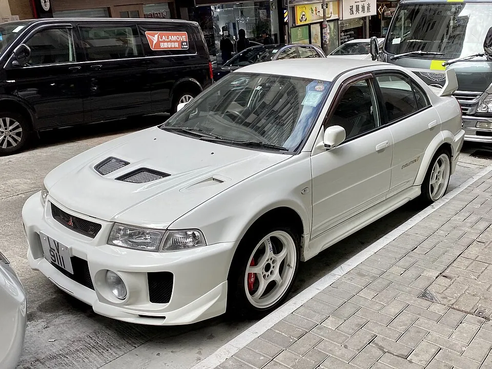 White Mitsubishi Lancer Evolution V, front three-quarter view on a Hong Kong street