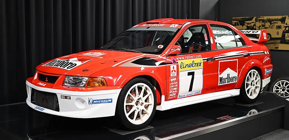 Red and white Mitsubishi Lancer Evolution VI Tommi Mäkinen Edition, three-quarter front view