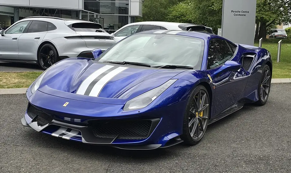 Blue Ferrari 488 Pista with white racing stripes, three-quarter front view