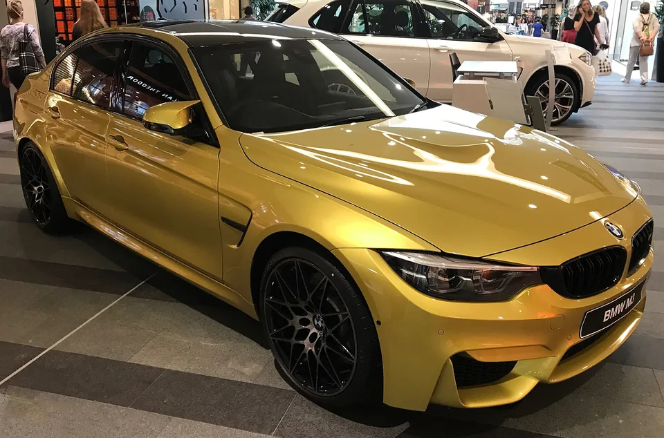 Yellow BMW M3 (F80) saloon, three-quarter front view