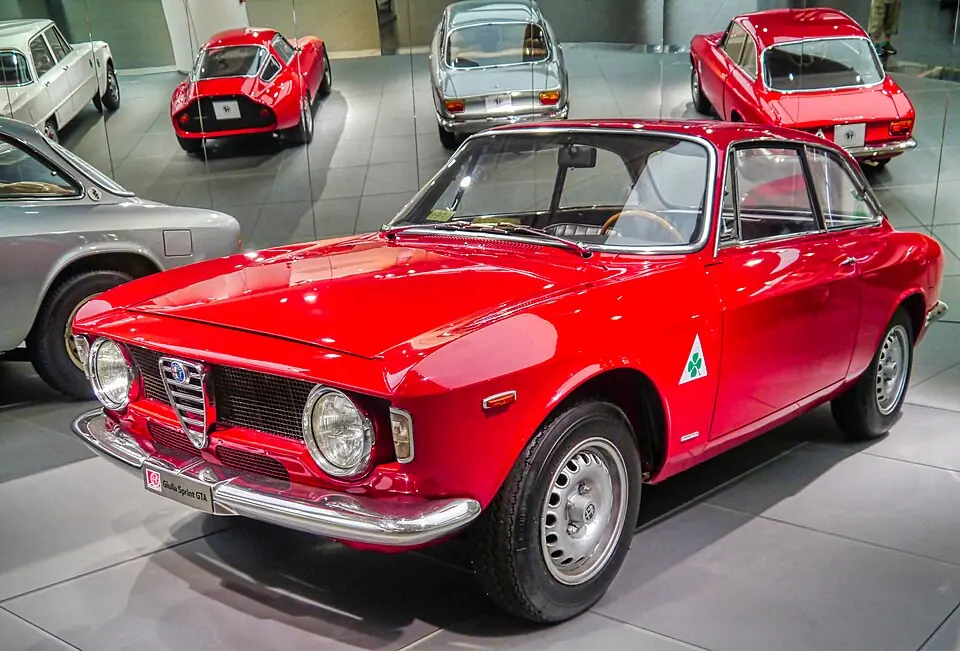 Red Alfa Romeo Giulia Sprint GTA with green cloverleaf badge, front three-quarter view, Alfa Romeo museum