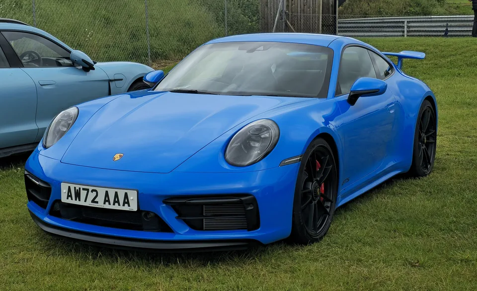 Shark Blue Porsche 911 Carrera GTS (992.1) coupé on grass at a British show, three-quarter front view