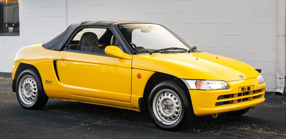 Yellow Honda Beat (PP1) with the soft top raised, three-quarter front view