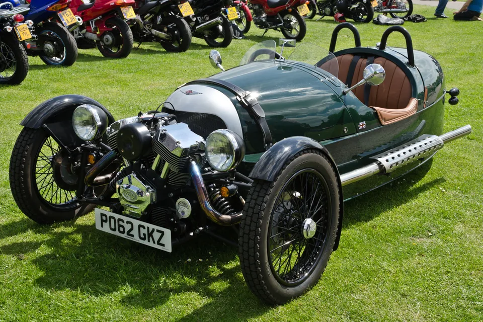 Green Morgan 3-Wheeler with the S&S V-twin exposed ahead of the front axle, three-quarter front view