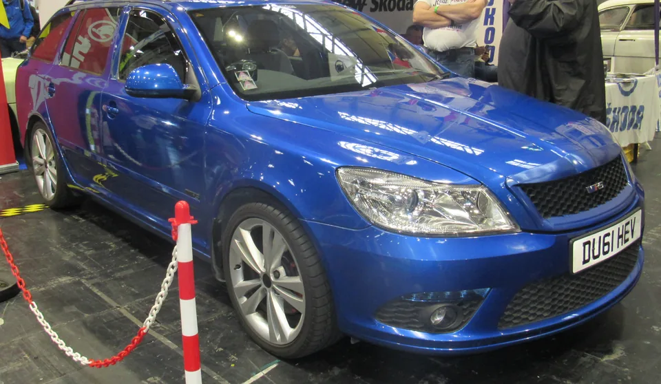 Blue Škoda Octavia vRS Combi (Mk2 facelift) at an indoor show, three-quarter front view with the vRS grille badge