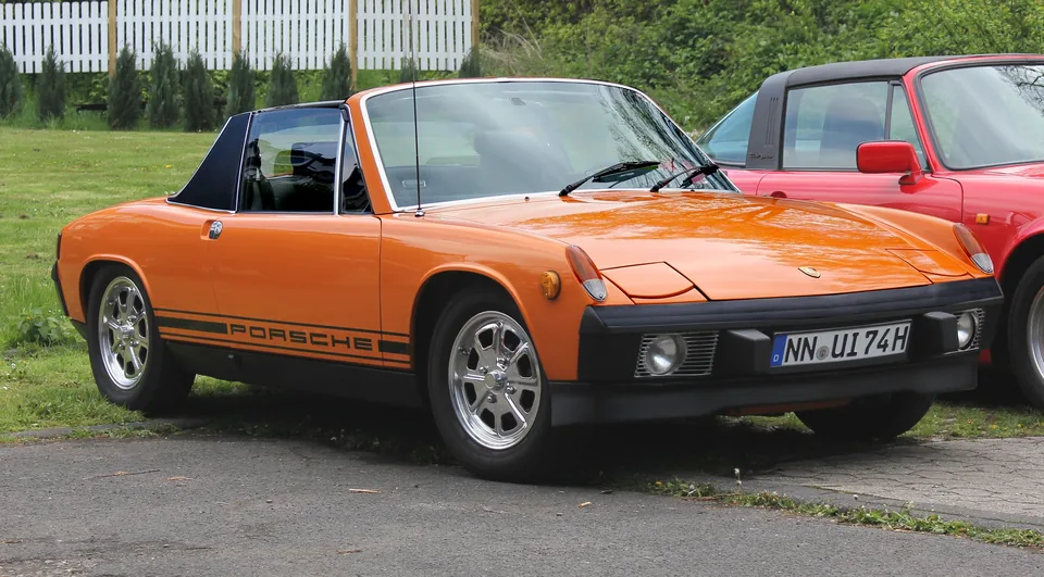 Orange Porsche 914 with the targa roof removed, three-quarter front view