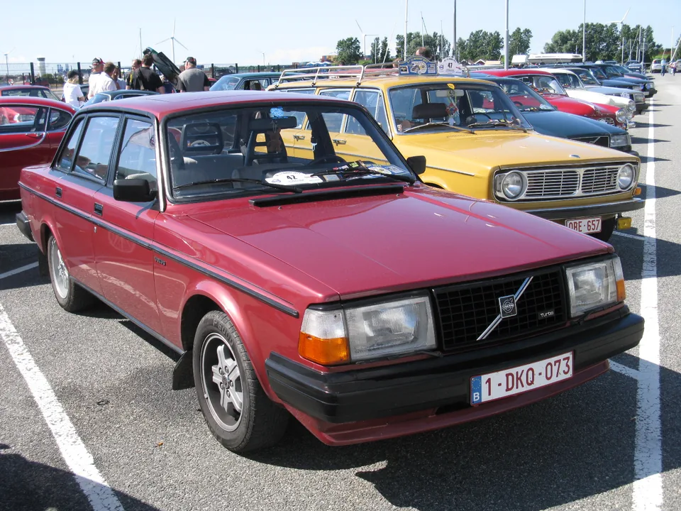 Red Volvo 244 Turbo at a classic meeting, three-quarter front view with the Turbo badge on the grille